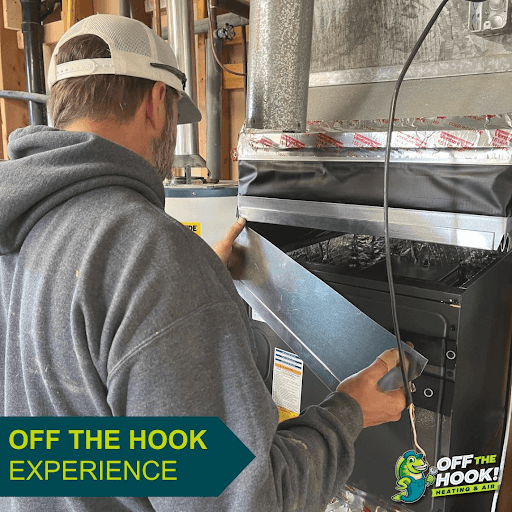 Off The Hook Heating & Air HVAC technician in front of a furnace needing replacement in Elk River